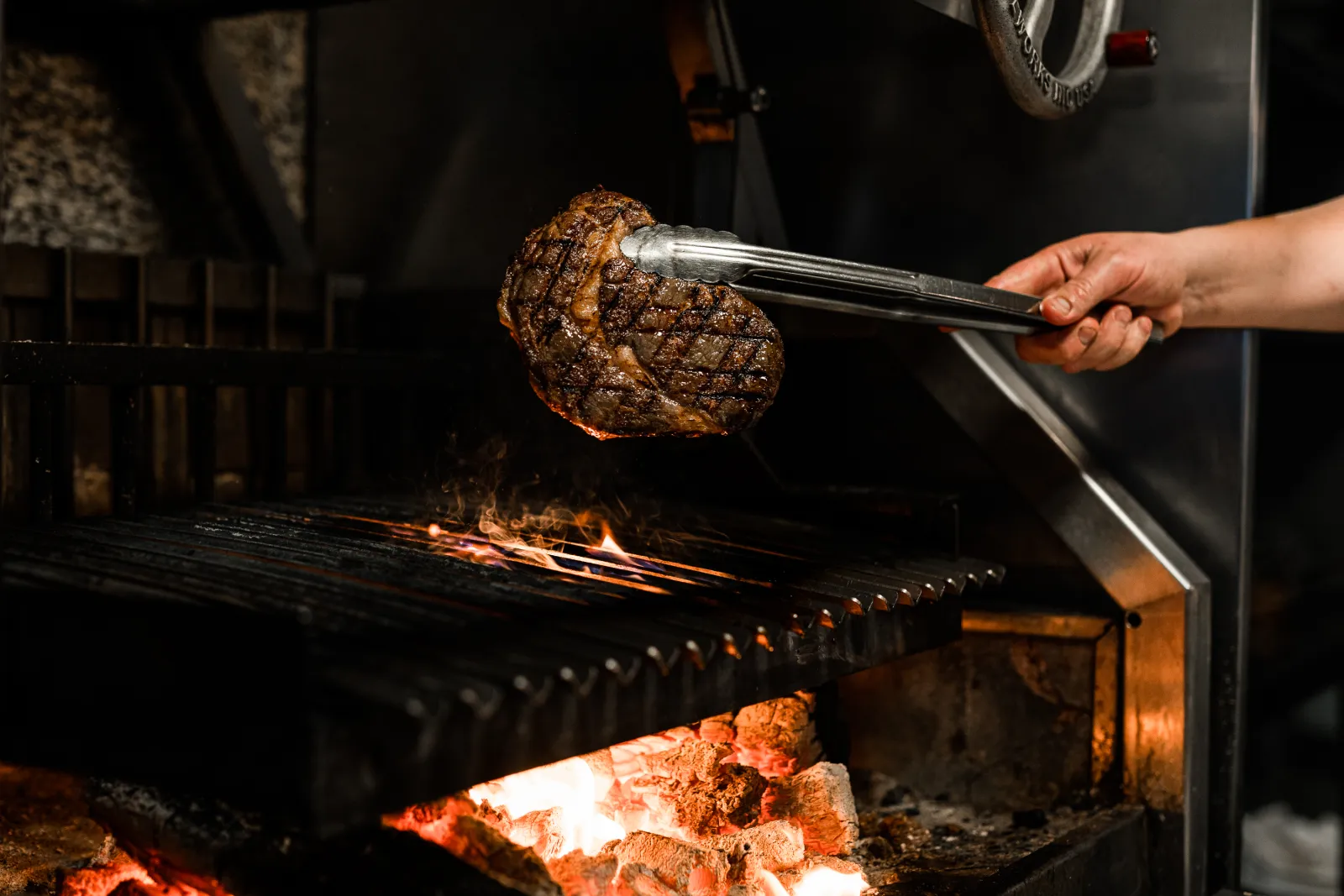 A huge wagyu steak is taken off the charcoal grill during the Carrara640 shoot with ShareStory