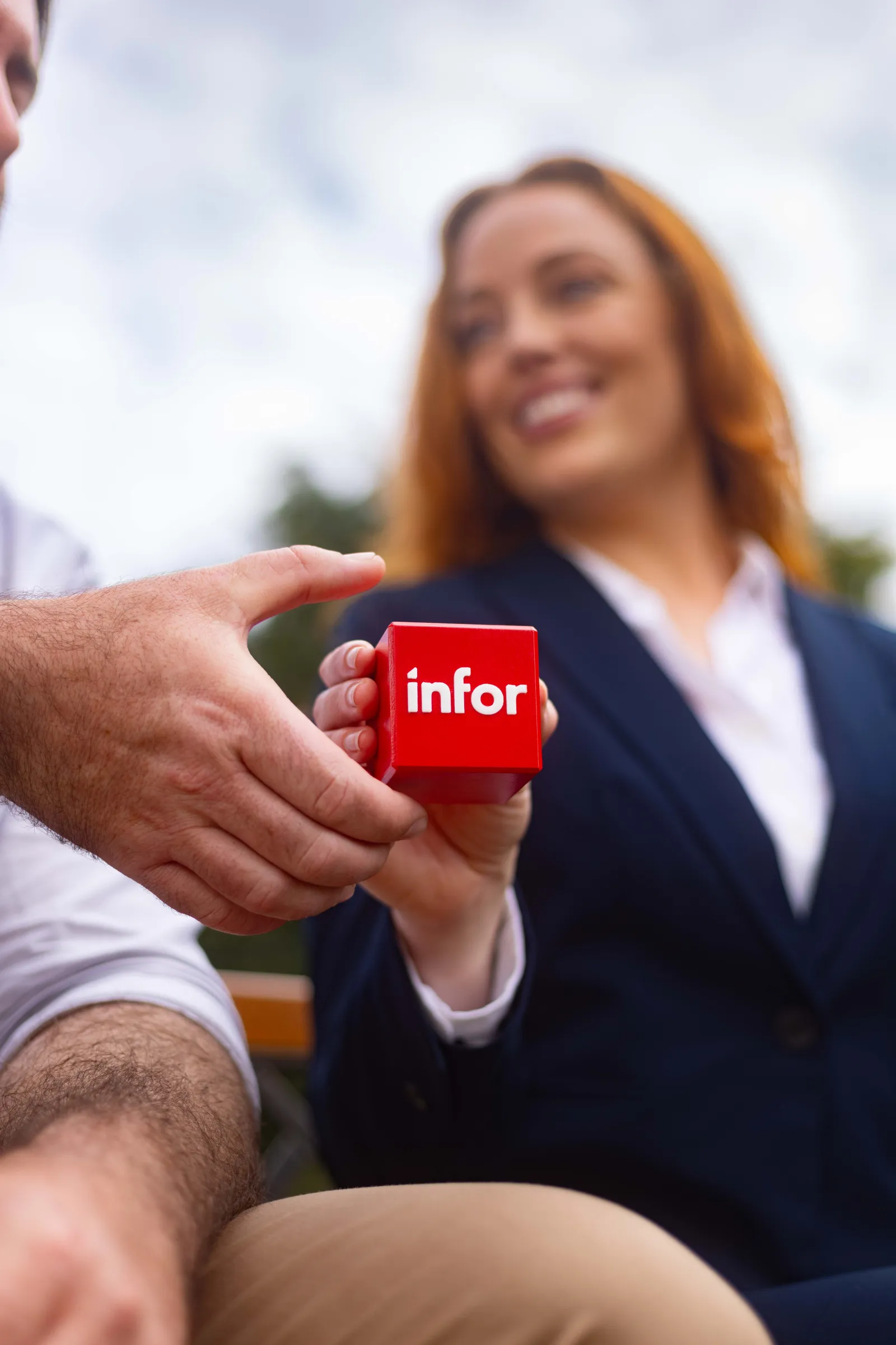 Pathway Paige presents the Infor cube to the camera for the Infor Pathway commercial with ShareStory.