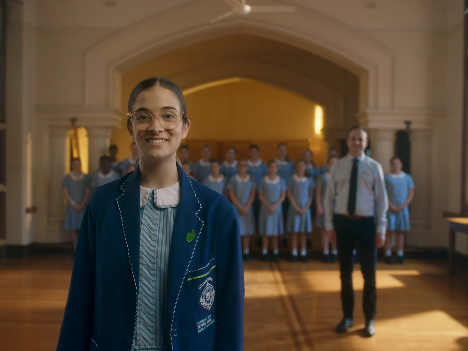 School Captain Charli stands in front of the Principal and the Stuartholme choir.